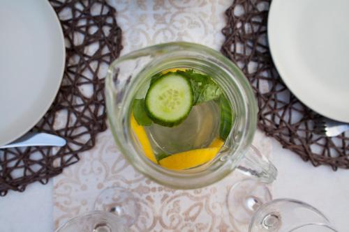 a drink in a glass jar with a cucumber and oranges at Medieval Dreams Villa in Rhodes Town