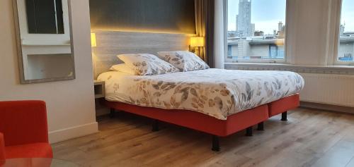 a bed in a room with a large window at Hotel Bor Scheveningen in Scheveningen