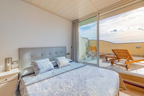 a bedroom with a bed and a balcony at InSitges Sant Sebastia's Beach in Sitges