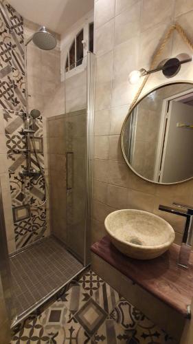 une salle de bain avec un lavabo et une douche avec un miroir dans l'établissement CHOCOLAT, à Bagnères-de-Bigorre