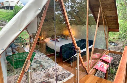 
a bedroom with a bed, chair, and table in it at Glamping Lumbre in Salento
