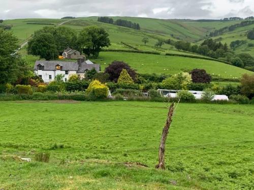 a house in the middle of a green field at Ty Capel in Llanidloes
