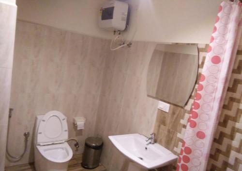a small bathroom with a toilet and a sink at Ocean Inn Hotels in Bengaluru