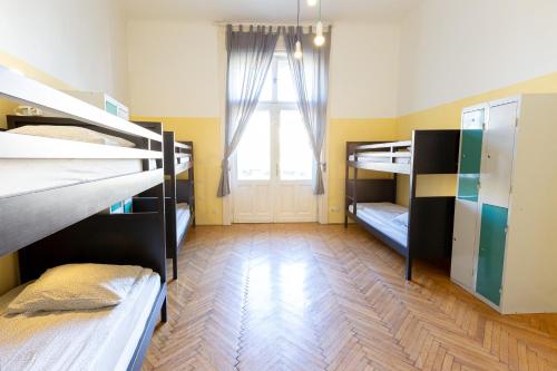 a room with three bunk beds and a window at Spicy Hostel in Budapest