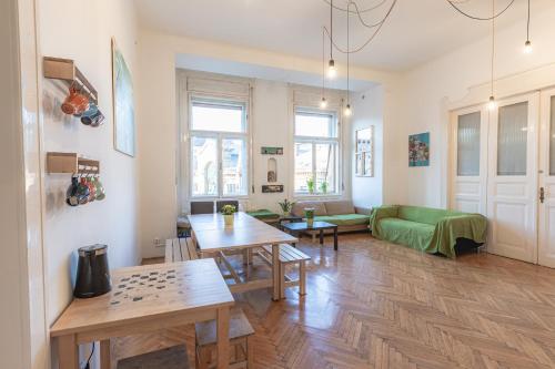 a living room with tables and a green couch at Spicy Hostel in Budapest