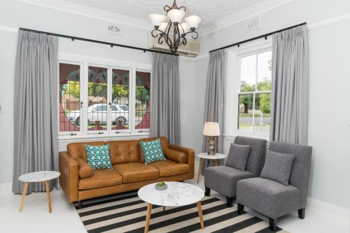 a living room with a couch and two chairs at Kirsten Accommodation Parkes in Parkes