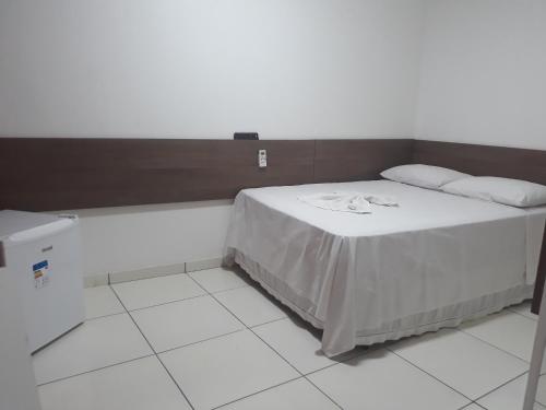 uma cama num quarto com piso branco em Pousada Pampa Gaúcho em Teresina