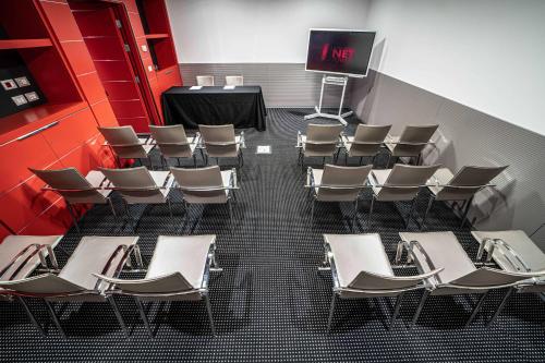 a room with chairs and a table and a screen at Best Western Plus Net Tower Hotel Padova in Padova
