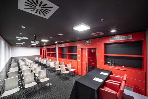 a conference room with red walls and white chairs at Best Western Plus Net Tower Hotel Padova in Padova