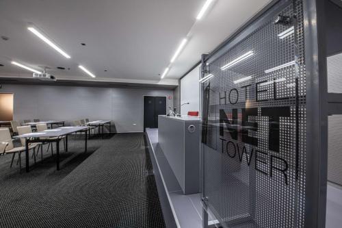 a conference room with tables and chairs and a glass wall at Best Western Plus Net Tower Hotel Padova in Padova