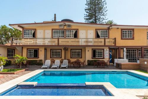 una casa con piscina frente a ella en Hotel Villas Santa Ana, en Boca del Río