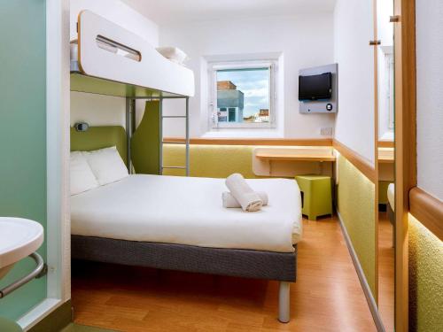 a small room with a bunk bed and a sink at ibis budget London Hounslow in Hounslow