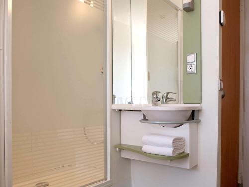 La salle de bains est pourvue d'un lavabo et d'un miroir. dans l'établissement Ibis Budget Lleida, à Lleida