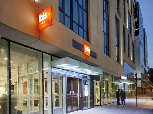 a facade of a building with people walking in front of it at ibis London Blackfriars in London