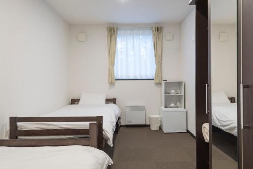 une chambre avec deux lits et une fenêtre dans l'établissement Niseko Wow Lodge, à Kutchan