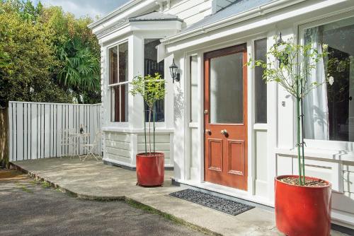 two potted plants sitting outside of a house at Pepper Tree Villa in Masterton