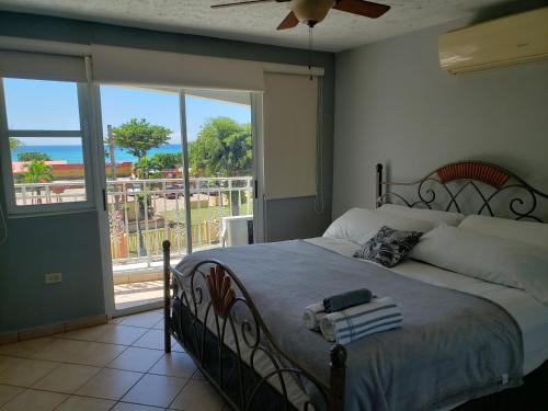 a bedroom with a bed with a view of the ocean at Wave View Village - Beach Front - Luxury Spot in Rincon