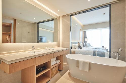 a bathroom with a large mirror and a tub at Yuyao Bright hotel in Yuyao