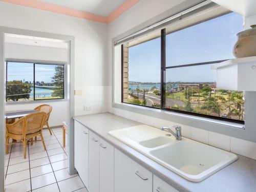 a kitchen with a sink and a window at Oxley 8 at Tuncurry in Tuncurry