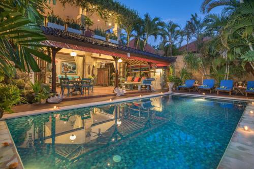 a swimming pool in front of a house at Villa Kaja by Nagisa Bali in Seminyak