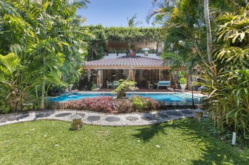 a house with a swimming pool in a yard at Villa Kaja by Nagisa Bali in Seminyak
