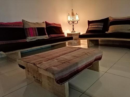 a room with two couches and a bench with pillows at Hotel Kachi de Uyuni in Uyuni