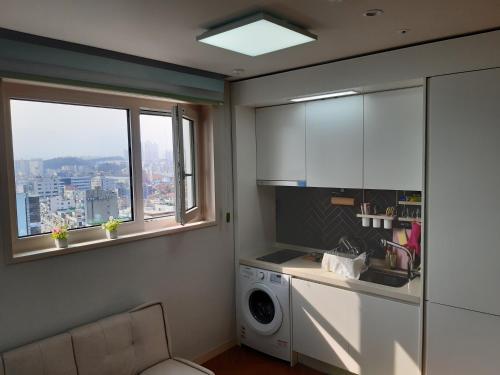 a kitchen with a washing machine and a window at SunriseHotel JuniorSuite room 11F Sea- view in Sokcho