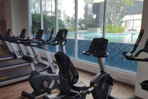 a gym with cardio machines and a swimming pool at Mesa Hill Nilai - Welcome to the Nautica in Nilai