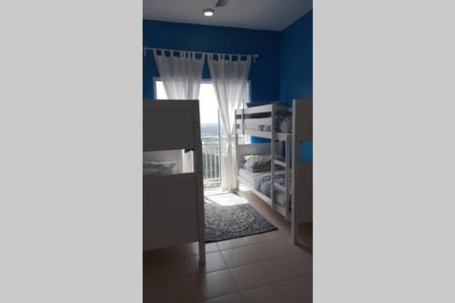 a bedroom with blue walls and a window at Mesa Hill Nilai - Welcome to the Nautica in Nilai