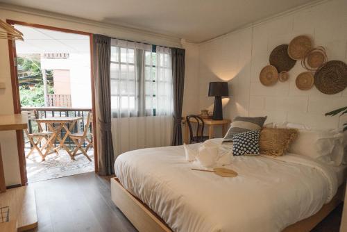 a bedroom with a large bed and a balcony at Stay North Gate Bed and Breakfast in Chiang Mai