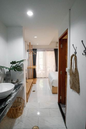 a bathroom with a sink and a bed in a room at Stay North Gate Bed and Breakfast in Chiang Mai