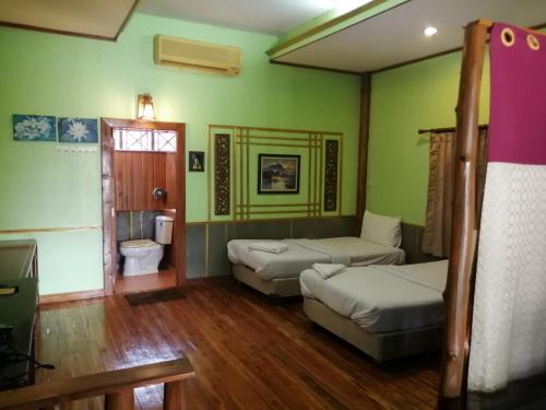 une chambre avec deux lits et un canapé dans l'établissement Nang Phraya Resort, à Ban Khok Mai Den (1)