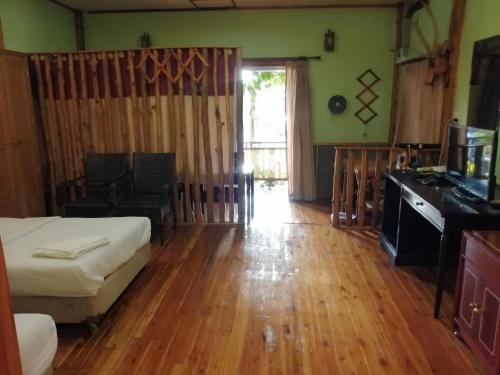 une chambre avec un lit, un bureau et une télévision dans l'établissement Nang Phraya Resort, à Ban Khok Mai Den (1)