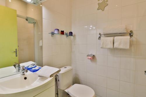 a white bathroom with a toilet and a sink at Palais Hongran de Fiana in Nice