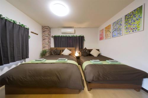 um quarto com duas camas num quarto em nestay suite tokyo tabata 03 em Tóquio