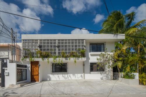 a white building with palm trees in front of it at Art Studios in Cancún