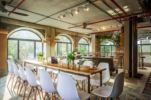 a dining room with a long table and white chairs at Bridges Danang Boutique Hotel in Danang