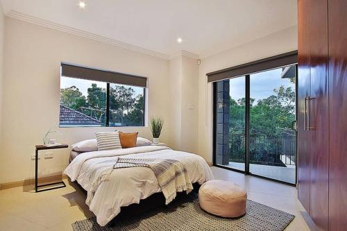 a bedroom with a large bed and a large window at Villa Modica in Ipswich