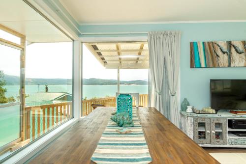 a living room with a view of the water at ONEPU MOANA 4-6 Bdr Holiday Home in Opononi