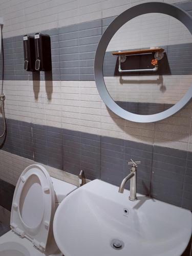a bathroom with a toilet and a sink and a mirror at Pakarang Resort in Satun