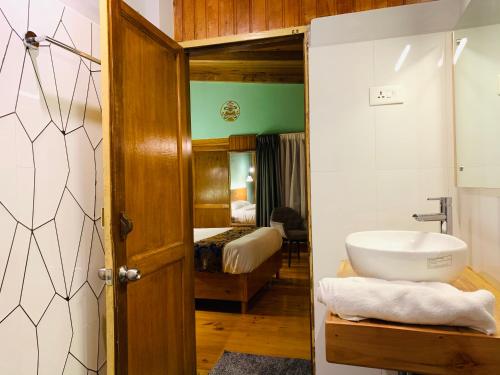 ein Bad mit einem Waschbecken und einem WC in einem Zimmer in der Unterkunft Dzi Pema in Paro