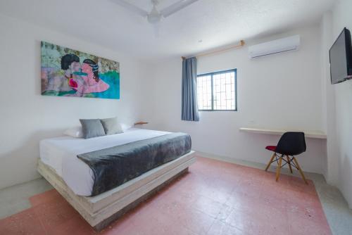 a bedroom with a bed and a painting on the wall at Art Studios in Cancún