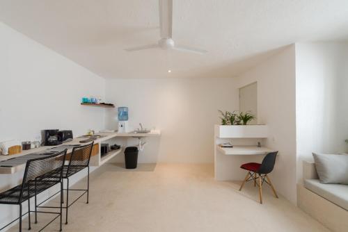 a white kitchen with black chairs and a table at Art Studios in Cancún