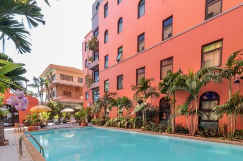 un hotel con piscina frente a un edificio en Baansuanprannok Hotel, en Bangkok