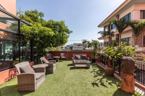 a patio with grass and chairs on a balcony at Baansuanprannok Hotel in Bangkok
