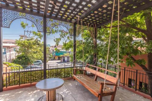 a swing on a balcony with a table and a table at Baansuanprannok Hotel in Bangkok