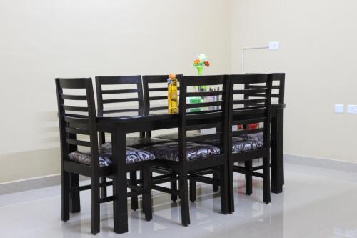 a black dining room table with four chairs at Phoenix Serviced Apartment - Sai Illam in Chennai