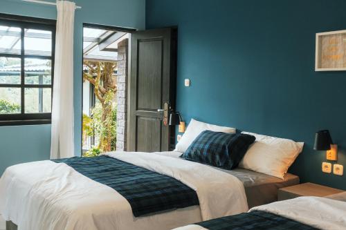 - une chambre bleue avec 2 lits et une fenêtre dans l'établissement Villa Baba By The Villas 100, à Puncak