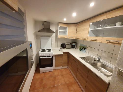 a small kitchen with a stove and a sink at Ferienwohnung Häusla in Hirschaid