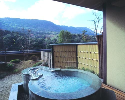a hot tub with a view of a mountain at Kotohira Onsen Kotosankaku in Kotohira